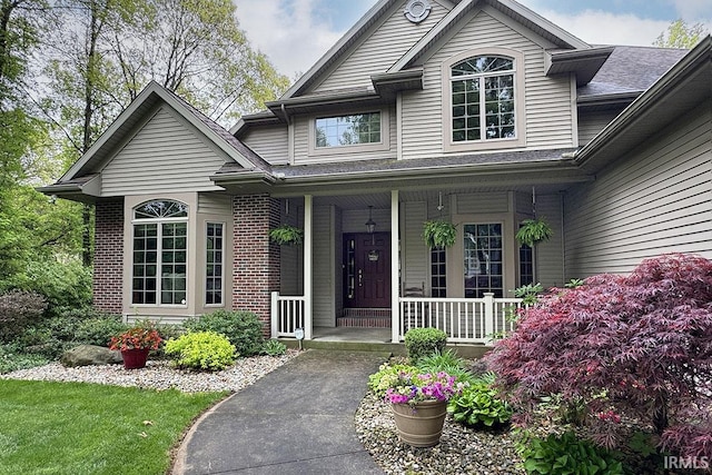 view of front facade with covered porch and brick siding