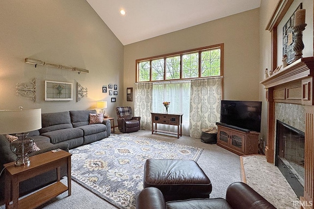 carpeted living room featuring high vaulted ceiling, a glass covered fireplace, and recessed lighting
