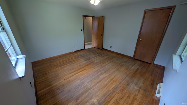 unfurnished bedroom with wood finished floors and baseboards