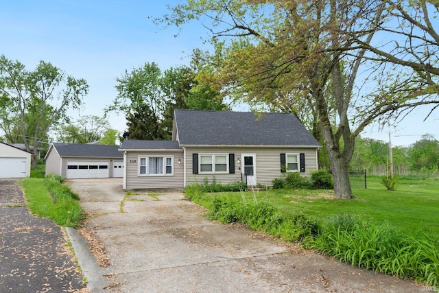 view of front of property with a front yard and a detached garage