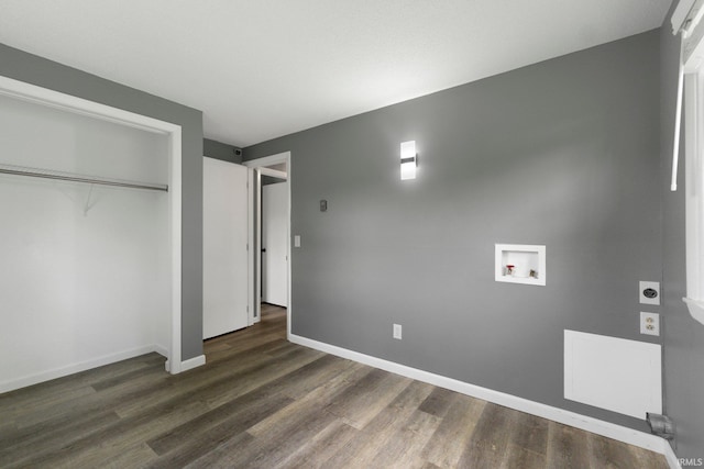 unfurnished bedroom featuring dark wood finished floors, baseboards, and a closet