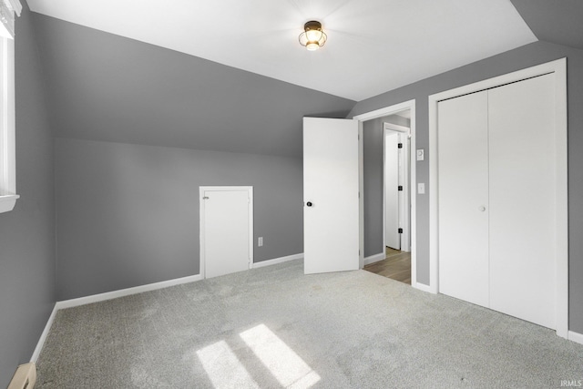 bonus room with lofted ceiling, carpet flooring, baseboard heating, and baseboards