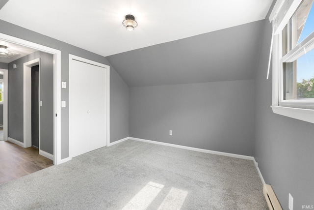 bonus room with carpet floors, vaulted ceiling, baseboards, and a baseboard heating unit