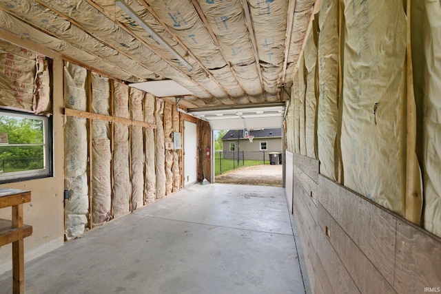 misc room with a garage and concrete floors