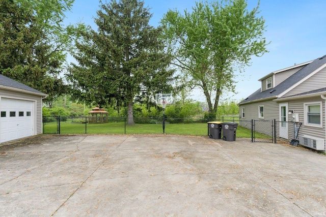view of patio featuring driveway, a garage, and a gazebo