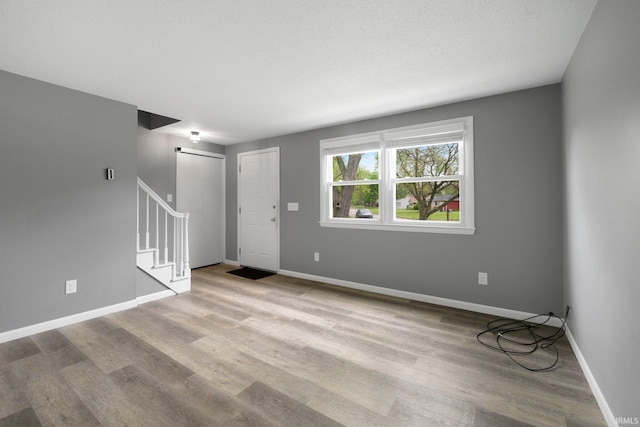 entrance foyer featuring stairway, wood finished floors, and baseboards