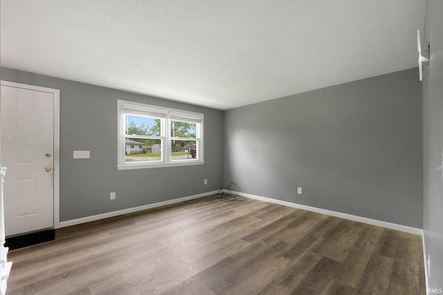 spare room featuring wood finished floors and baseboards