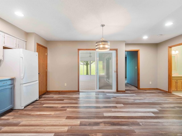 unfurnished dining area featuring baseboards, light wood-style floors, and recessed lighting