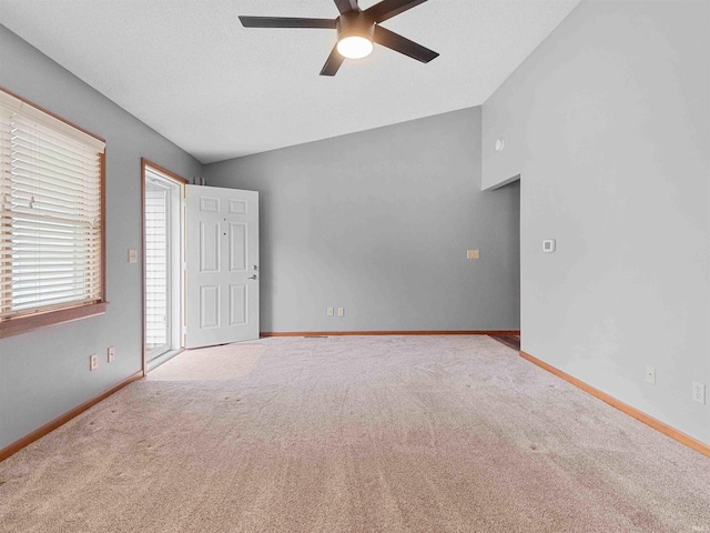 carpeted empty room with a ceiling fan and baseboards