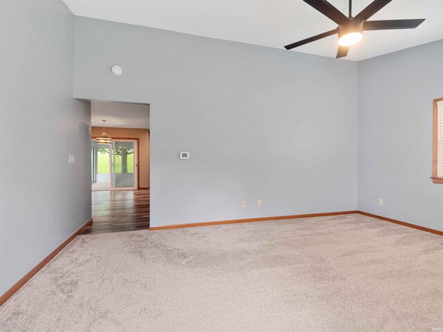carpeted empty room featuring baseboards and ceiling fan