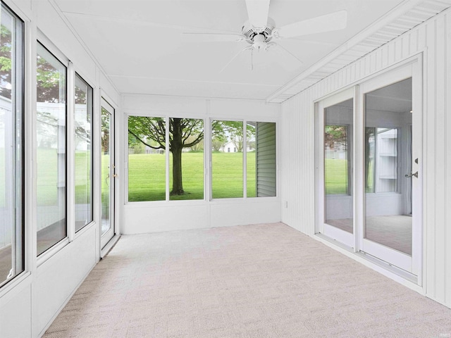 unfurnished sunroom with a ceiling fan and plenty of natural light