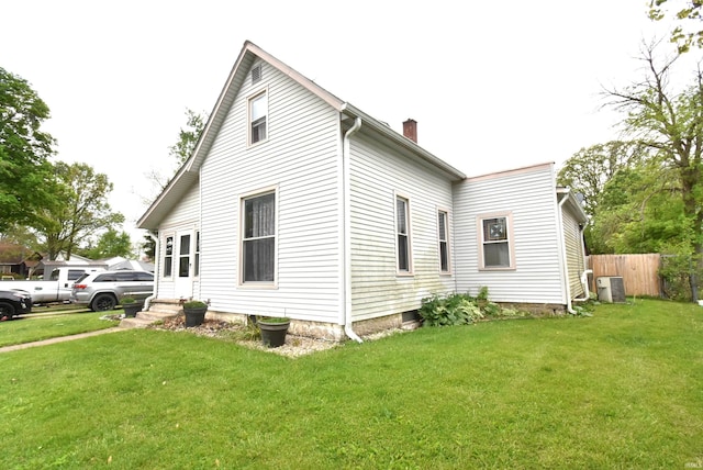 view of side of home with a chimney, entry steps, and central air condition unit