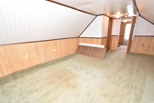 additional living space with wood walls, vaulted ceiling, and carpet floors