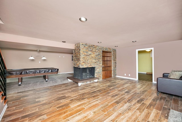 3016 S E Lake Dr, Elkhart, IN 46514 - unfurnished living room with baseboards, wood finished floors, a stone fireplace, built in shelves, and recessed lighting