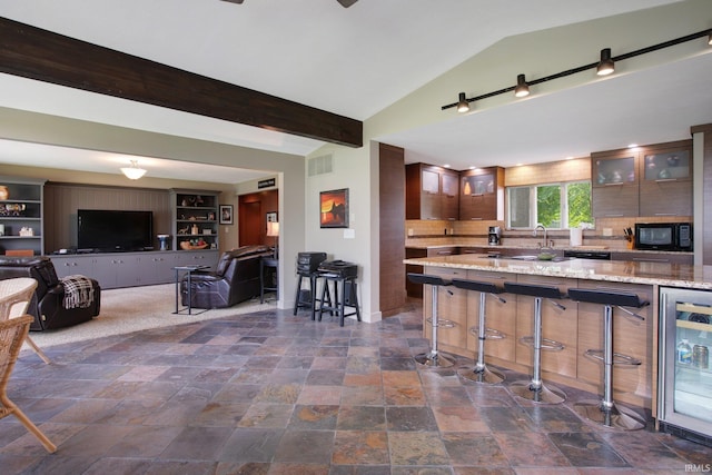 22147 Sunset Ln, Elkhart, IN 46516 - kitchen featuring black microwave, wine cooler, dark stone finish flooring, lofted ceiling, and glass insert cabinets