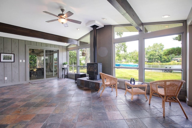 22147 Sunset Ln, Elkhart, IN 46516 - sunroom / solarium featuring a wood stove, a ceiling fan, and beam ceiling