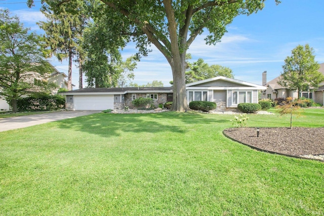 22147 Sunset Ln, Elkhart, IN 46516 - ranch-style house with stone siding, concrete driveway, a garage, and a front lawn