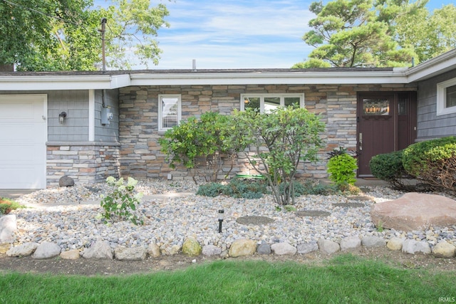 22147 Sunset Ln, Elkhart, IN 46516 - doorway to property featuring stone siding and an attached garage