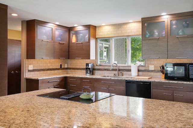 22147 Sunset Ln, Elkhart, IN 46516 - kitchen with black appliances, a sink, backsplash, light stone counters, and recessed lighting
