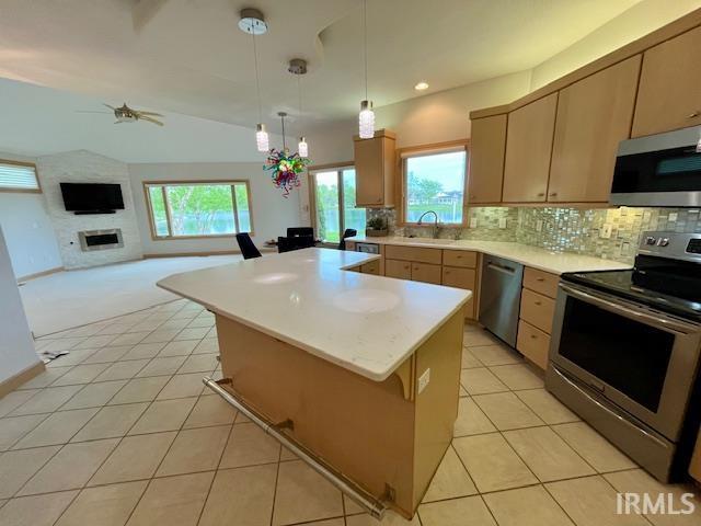 kitchen featuring stainless steel appliances, a sink, light tile patterned flooring, light countertops, and tasteful backsplash