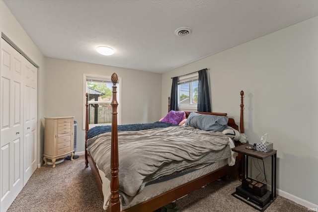 carpeted bedroom featuring baseboards and a closet