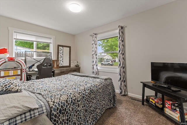 carpeted bedroom with multiple windows and baseboards