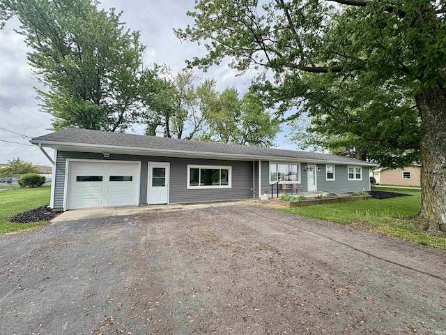 ranch-style house featuring an attached garage, asphalt driveway, and a front yard