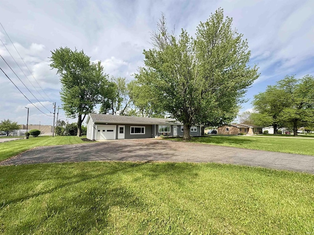 ranch-style home featuring asphalt driveway, an attached garage, and a front lawn