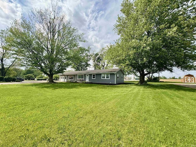 view of grassy yard featuring an outbuilding and a storage unit