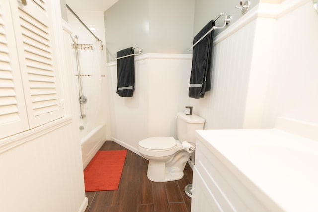 bathroom featuring toilet, wood finished floors, shower / bathtub combination with curtain, vanity, and baseboards