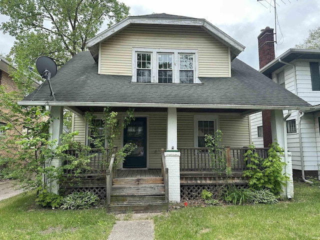 bungalow-style home featuring covered porch and a shingled roof