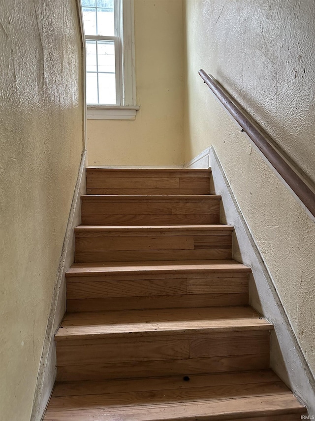 stairway featuring a textured wall