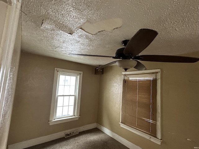 unfurnished room featuring a textured ceiling, ceiling fan, baseboards, and carpet flooring