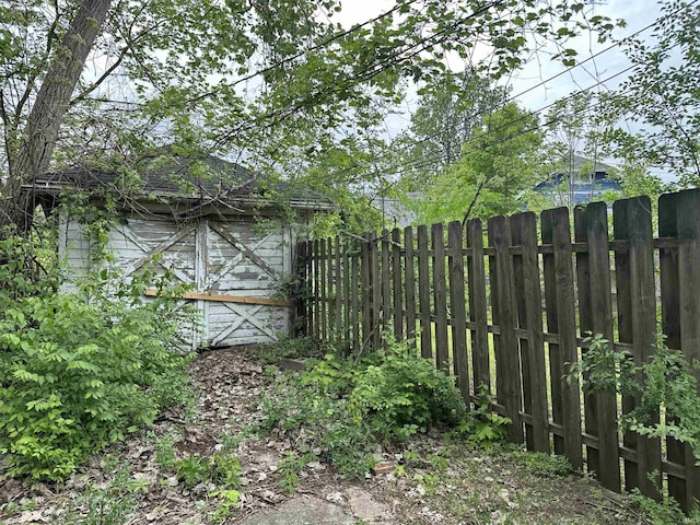 view of yard featuring fence, a storage shed, and an outdoor structure