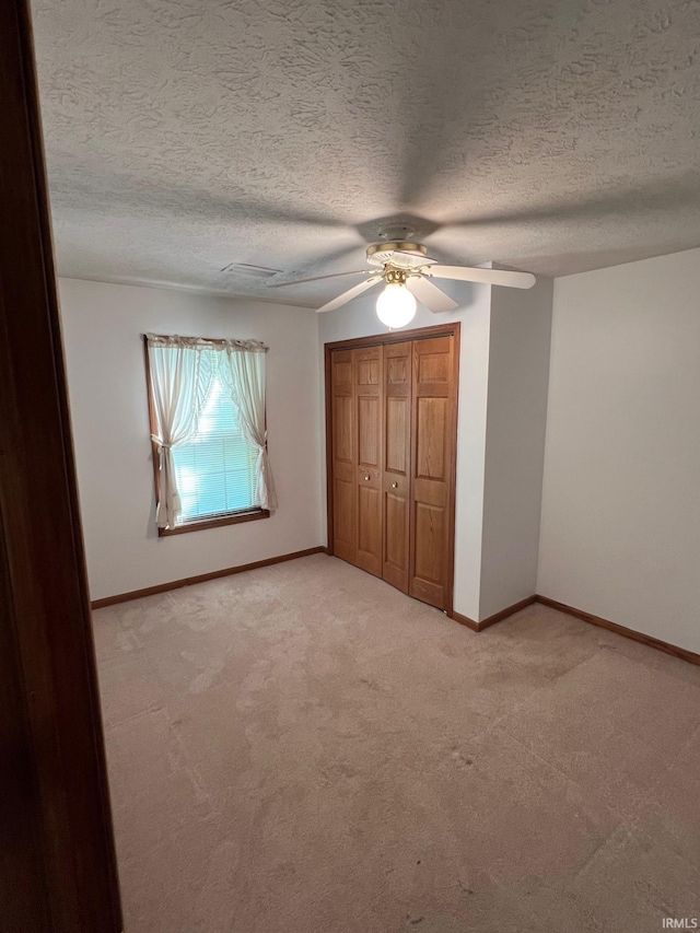 211 Mccutcheon Dr, Lafayette, IN 47909 - unfurnished bedroom featuring light carpet, baseboards, a closet, ceiling fan, and a textured ceiling