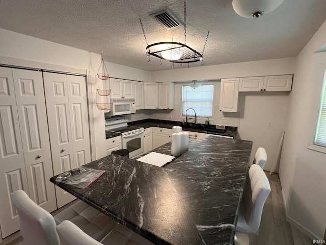 211 Mccutcheon Dr, Lafayette, IN 47909 - kitchen with white appliances, white cabinets, a sink, wood finished floors, and baseboards