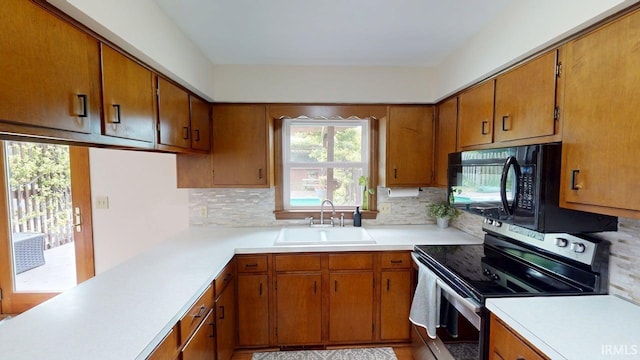 601 E 21st St, Ferdinand, IN 47532 - kitchen with stainless steel range with electric cooktop, a sink, black microwave, and brown cabinetry