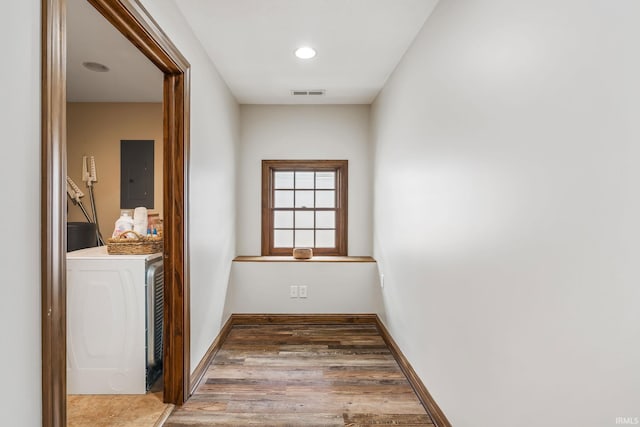 hall with electric panel, washer / dryer, wood finished floors, baseboards, and recessed lighting
