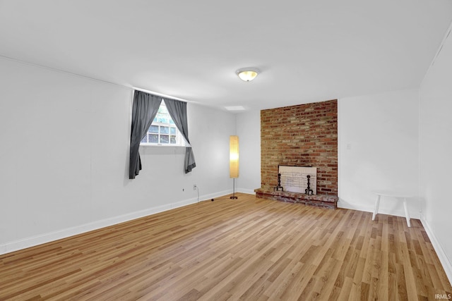 unfurnished living room featuring light wood-type flooring, a fireplace, and baseboards