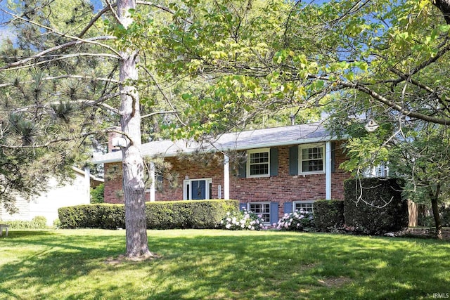 bi-level home with brick siding and a front yard