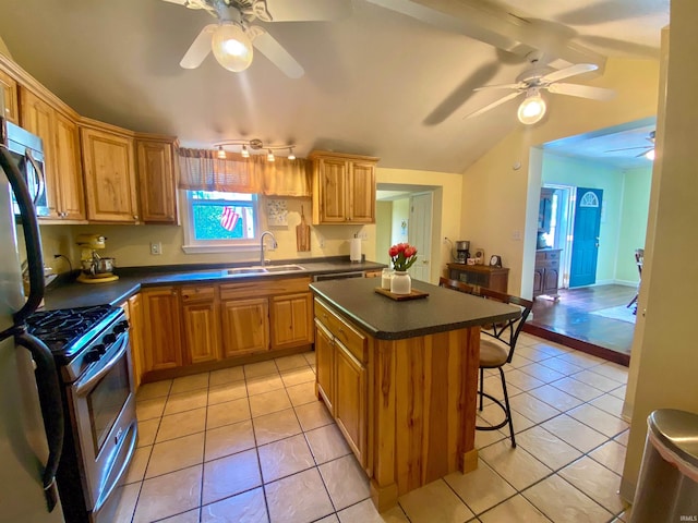 kitchen featuring appliances with stainless steel finishes, a ceiling fan, a sink, and dark countertops