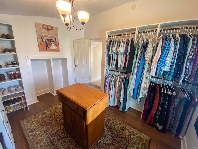 walk in closet with wood finished floors and a chandelier