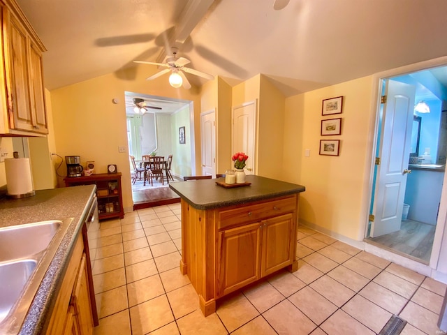 kitchen with ceiling fan, dark countertops, a sink, light tile patterned flooring, and a center island