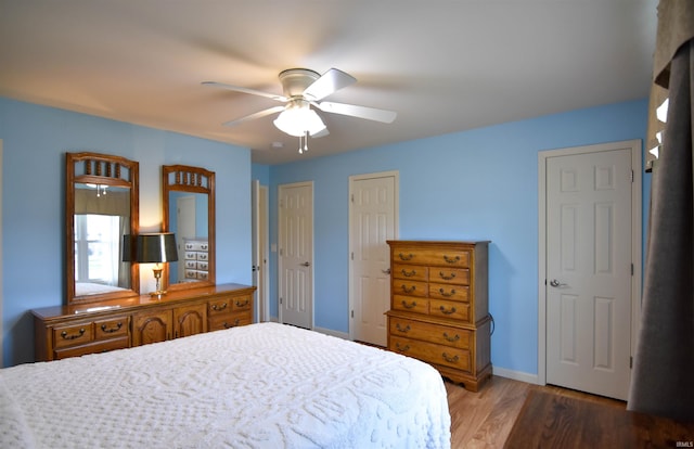 4101 Saddlebrooke Ln, Evansville, IN 47715 - bedroom featuring wood finished floors, two closets, baseboards, and ceiling fan