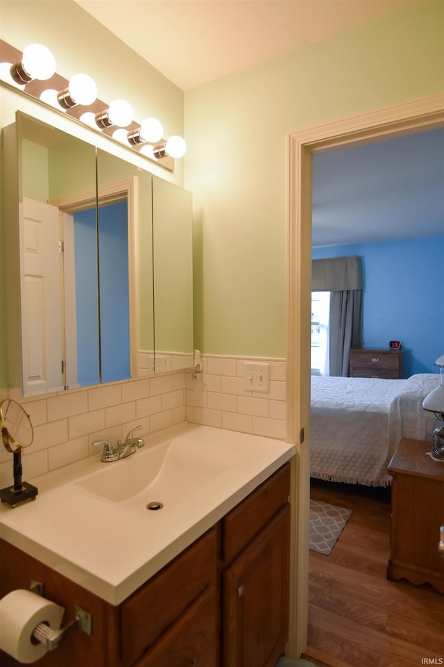 4101 Saddlebrooke Ln, Evansville, IN 47715 - bathroom with wood finished floors, vanity, decorative backsplash, and ensuite bathroom