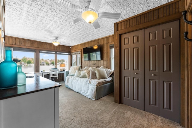 bedroom featuring an ornate ceiling, light carpet, access to exterior, ceiling fan, and wood walls