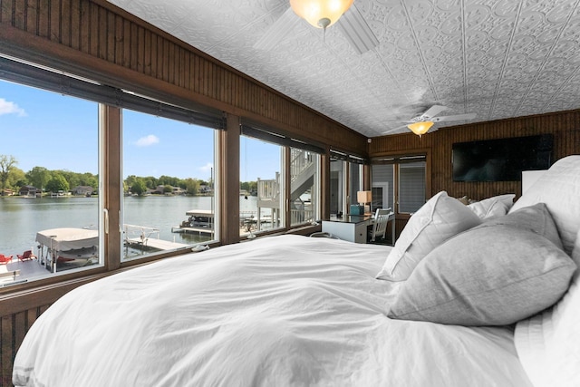 bedroom with a water view, access to outside, and an ornate ceiling