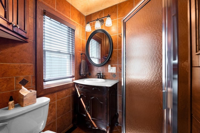 full bath with tile walls, vanity, toilet, and a shower stall