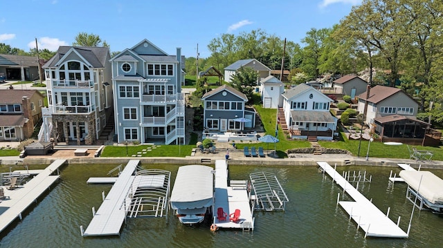 dock area with a water view, a balcony, and a residential view