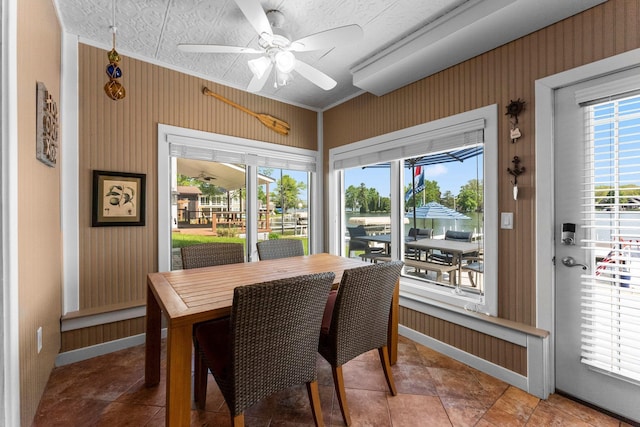 dining room featuring ceiling fan, baseboards, and wallpapered walls
